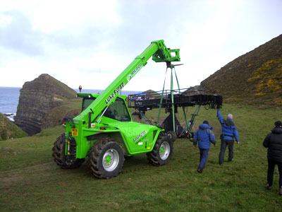 Telehandler moving filming crane into position at Hartland Cliffs, Devon.